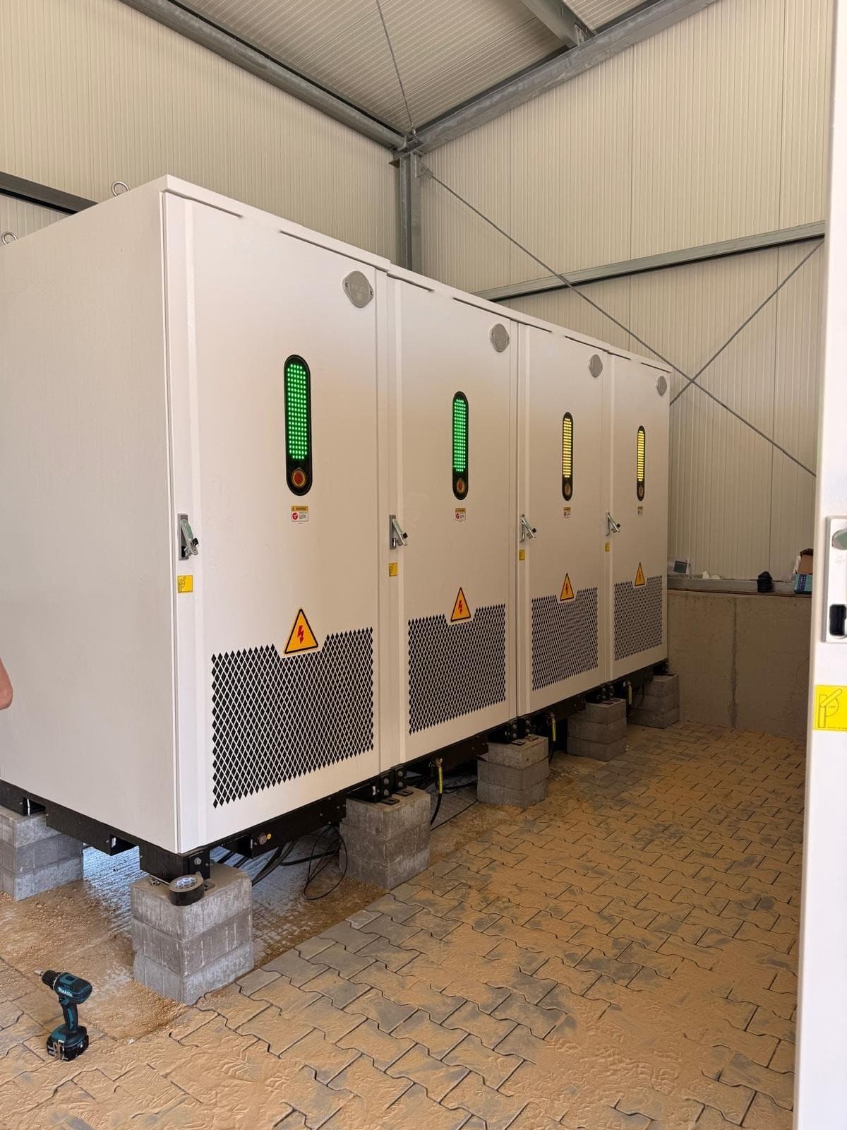 Batterijkasten met groene laadindicatoren binnen in een hal