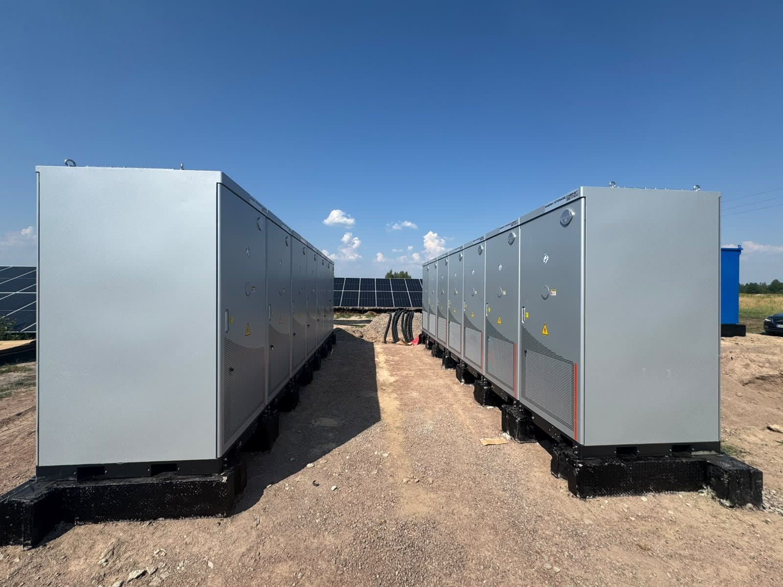Twee rijen batterijkasten op een zonnepark